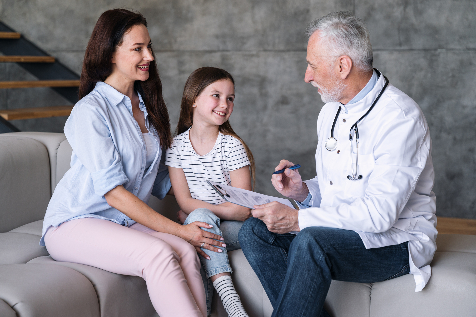 A doctor discussing with a mother and her young daughter during a consultation.