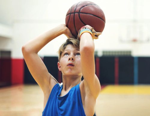 Young basketball player preparing to shoot the ball in a gymnasium.